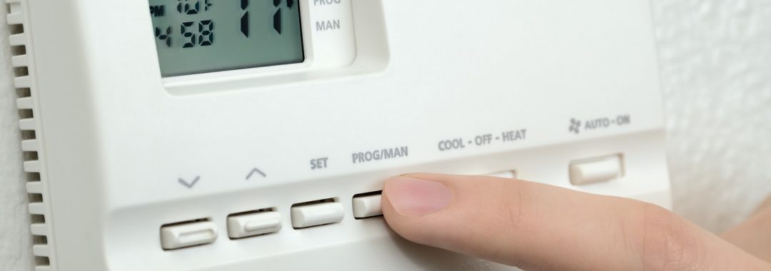 Woman testing an old thermostat